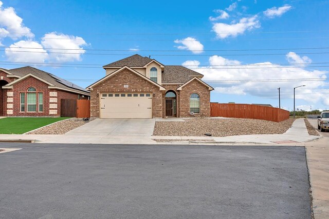 5700 San Miguel Ave, Midland, TX 79705 - traditional home with brick siding, fence, an attached garage, concrete driveway, and a shingled roof