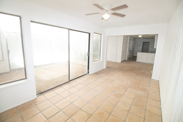 unfurnished bedroom featuring ceiling fan, light tile patterned floors, and a closet