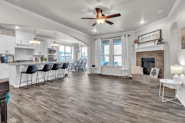 4107 Connally St, Big Spring, TX 79720 - kitchen featuring stainless steel appliances, open floor plan, arched walkways, dark wood-style floors, and ceiling fan
