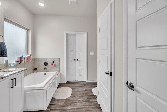4107 Connally St, Big Spring, TX 79720 - bathroom with a garden tub, vanity, wood finished floors, and recessed lighting