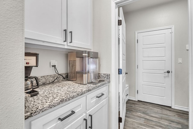 4107 Connally St, Big Spring, TX 79720 - kitchen featuring wood finished floors, white cabinets, and light stone countertops