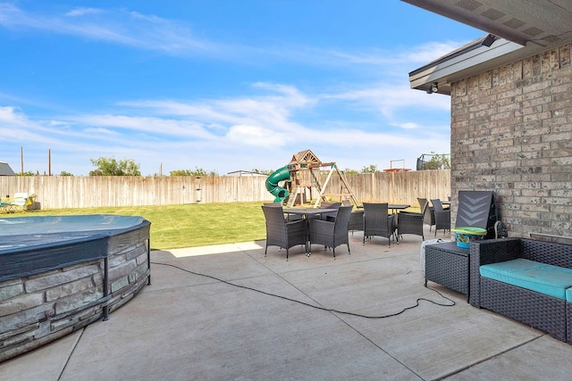 4107 Connally St, Big Spring, TX 79720 - fenced backyard with a hot tub, a patio, a playground, and outdoor dining space