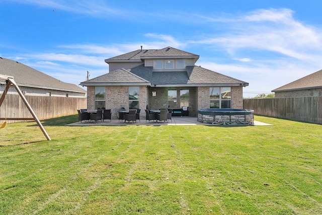 4107 Connally St, Big Spring, TX 79720 - rear view of house featuring a fenced backyard, a patio, a shingled roof, and brick siding