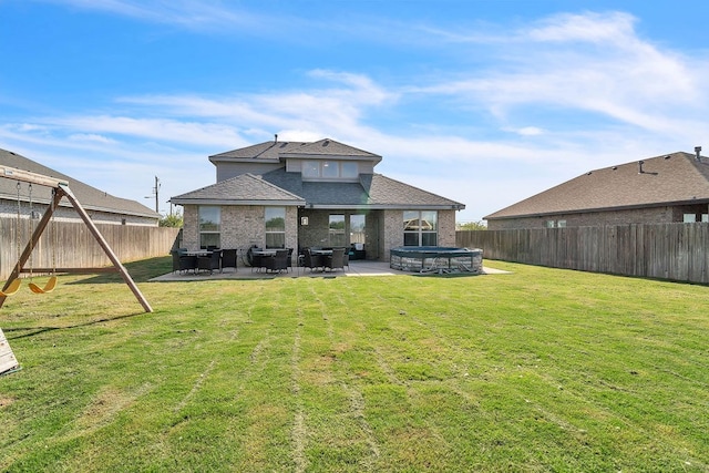 4107 Connally St, Big Spring, TX 79720 - back of house with a fenced backyard, a patio, a hot tub, a shingled roof, and brick siding