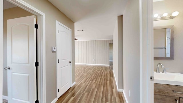 hall featuring sink and light wood-type flooring