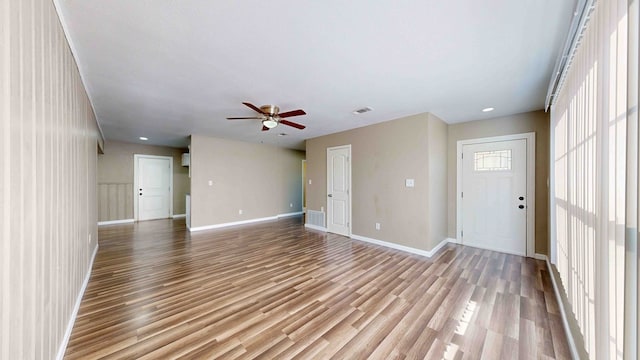 unfurnished living room featuring ceiling fan and light wood-type flooring