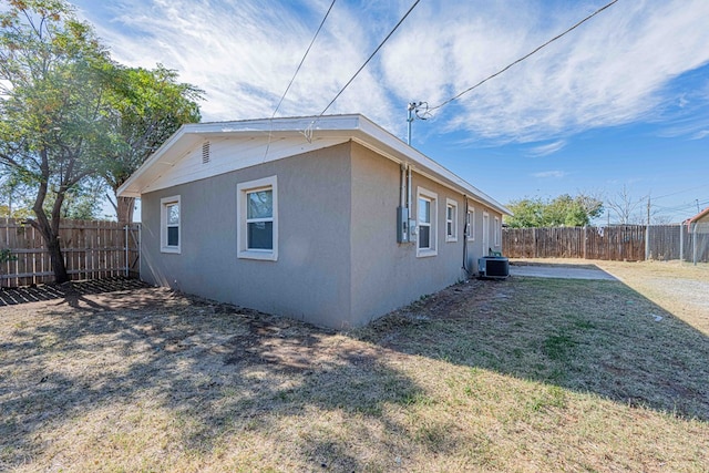 view of side of property with a lawn and central air condition unit