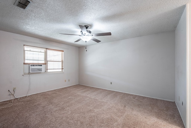 carpeted spare room featuring visible vents, cooling unit, a textured ceiling, and ceiling fan