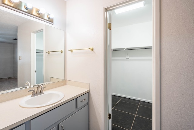 bathroom featuring vanity, tile patterned floors, and a spacious closet