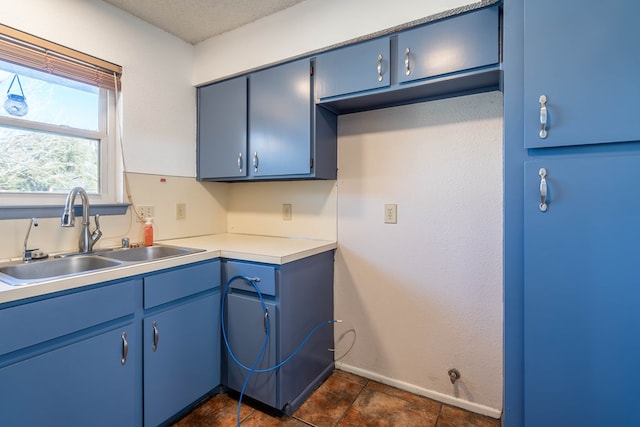 kitchen with a sink, blue cabinets, and light countertops