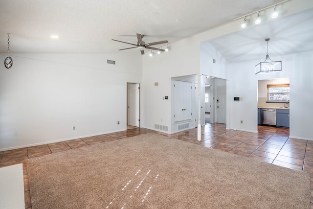 unfurnished living room featuring visible vents, ceiling fan with notable chandelier, carpet, and tile patterned flooring