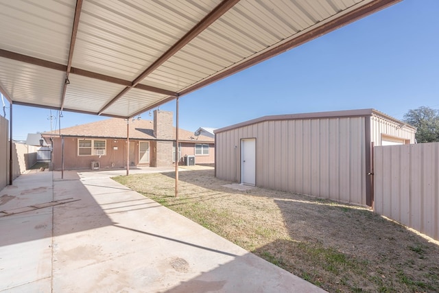 view of yard with a fenced backyard, cooling unit, an outdoor structure, and a patio area