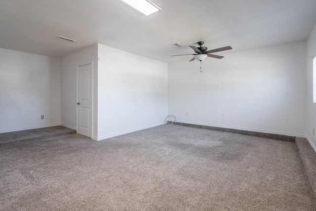 spare room featuring visible vents, baseboards, ceiling fan, and carpet floors