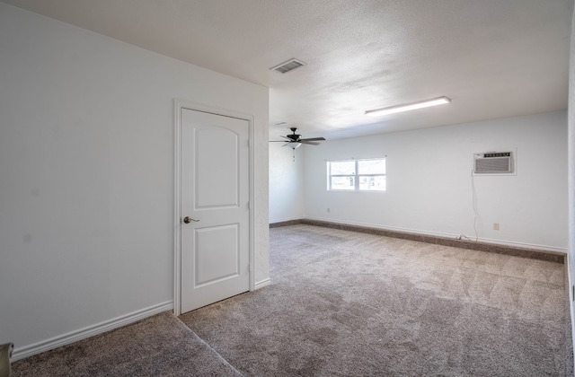 empty room with visible vents, baseboards, carpet, and a wall unit AC