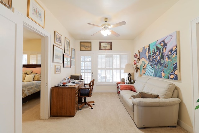 carpeted home office featuring ceiling fan