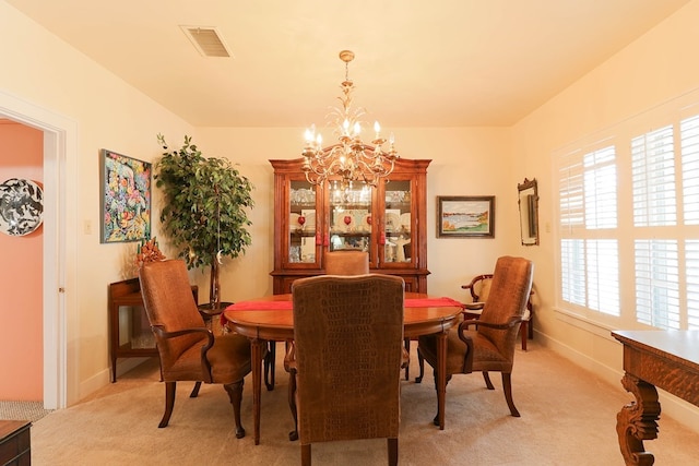 carpeted dining area featuring a notable chandelier