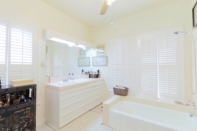 bathroom with ceiling fan, a tub to relax in, and vanity