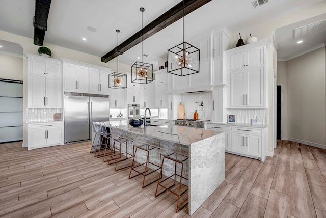 kitchen with stainless steel built in fridge, a sink, backsplash, and a breakfast bar area