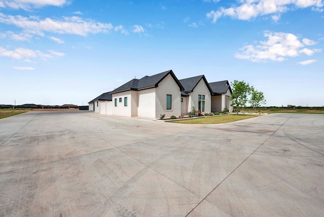 modern farmhouse with concrete driveway and brick siding