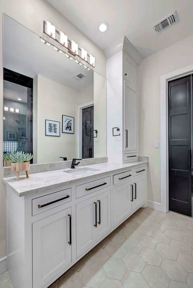 full bathroom featuring baseboards, vanity, and visible vents
