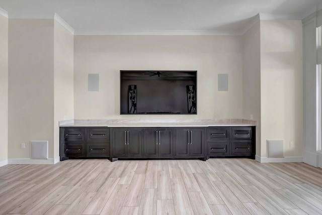 unfurnished living room featuring light wood-style flooring, baseboards, and ornamental molding