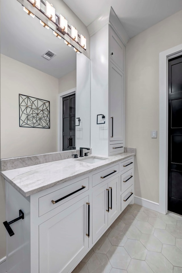 bathroom with baseboards, visible vents, tile patterned flooring, and vanity
