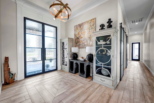 interior space featuring visible vents, a wealth of natural light, stacked washing maching and dryer, and a barn door