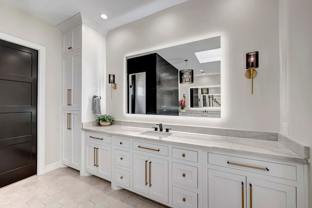 bathroom featuring tile patterned flooring, a skylight, vanity, and recessed lighting