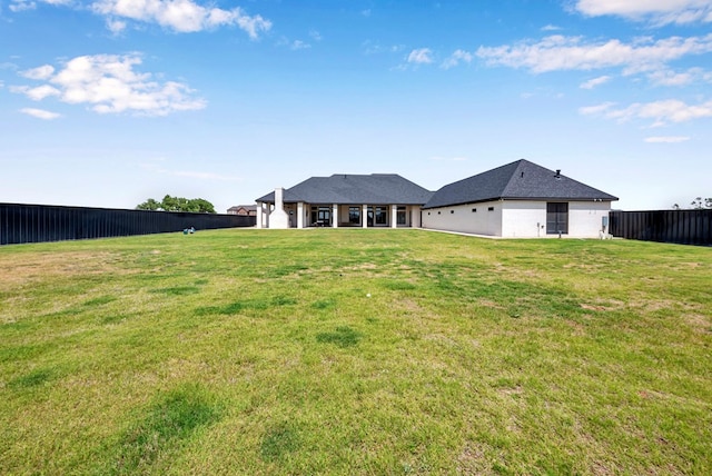 back of house with fence and a lawn