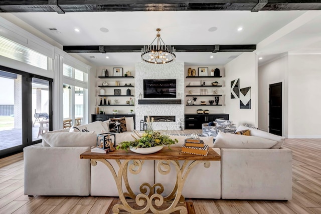 living area with a fireplace, beam ceiling, a chandelier, and light wood-style flooring