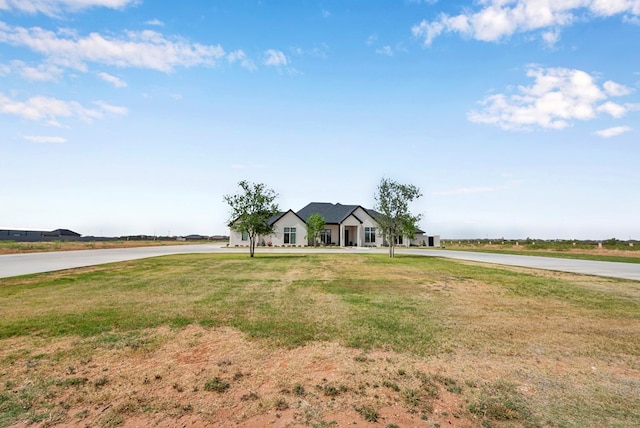view of front of property with a front yard and curved driveway
