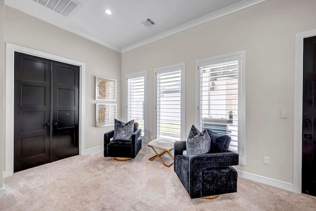 sitting room featuring carpet floors, visible vents, crown molding, and baseboards