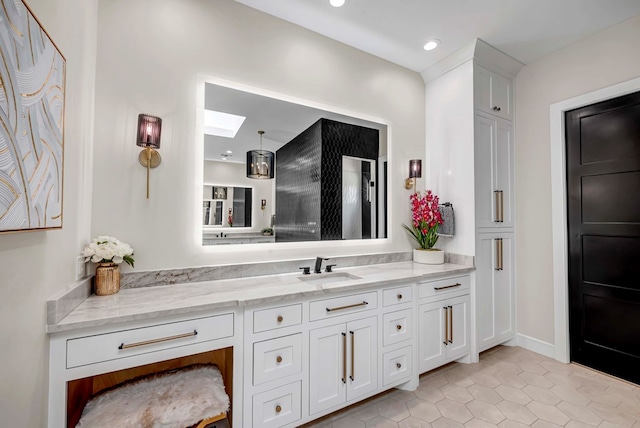 bathroom with tile patterned flooring, a skylight, vanity, and recessed lighting