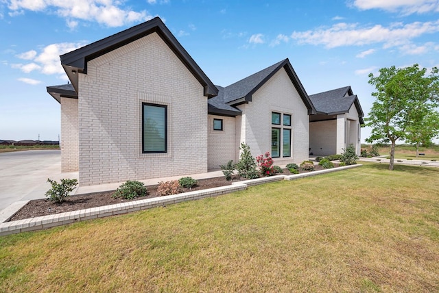view of front of home with brick siding and a front yard