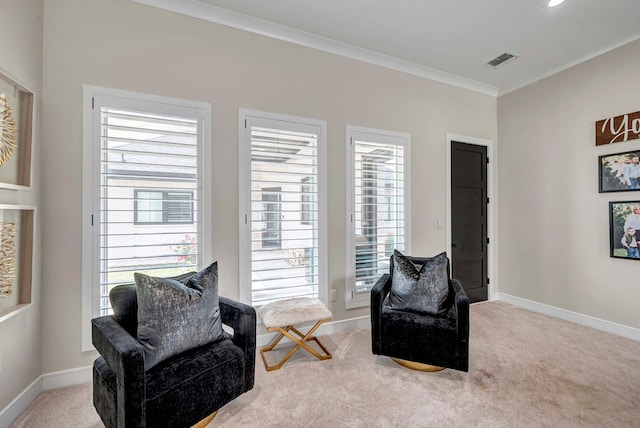 sitting room featuring carpet floors, visible vents, baseboards, and ornamental molding