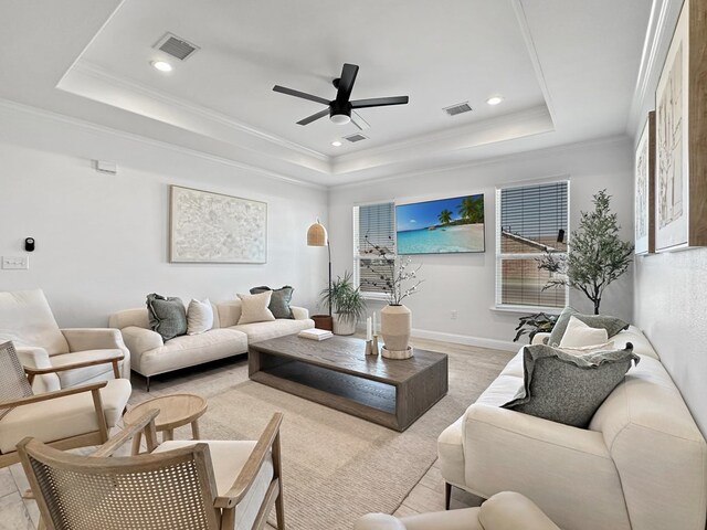 living room with ceiling fan, crown molding, and a tray ceiling