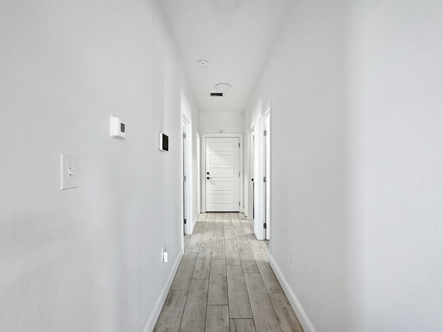 corridor with light hardwood / wood-style floors