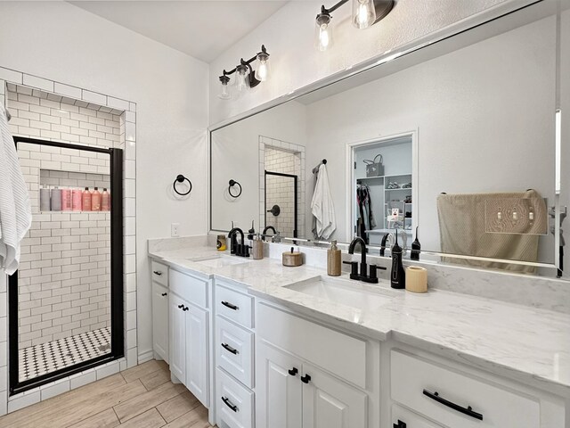 bathroom with hardwood / wood-style flooring, vanity, and walk in shower