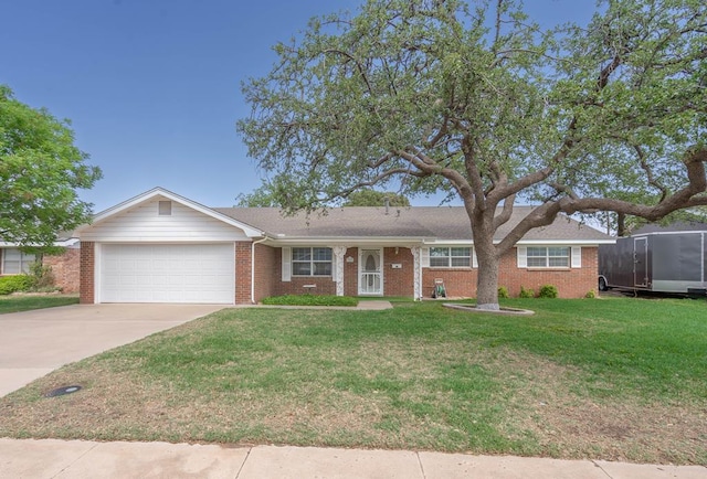 ranch-style home with concrete driveway, brick siding, an attached garage, and a front yard