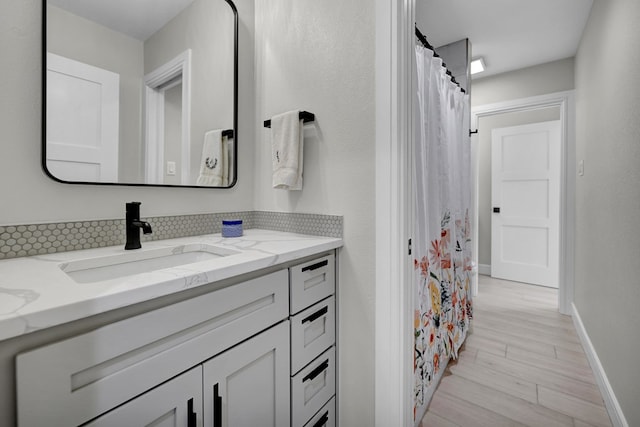 bathroom featuring vanity, baseboards, and wood finished floors