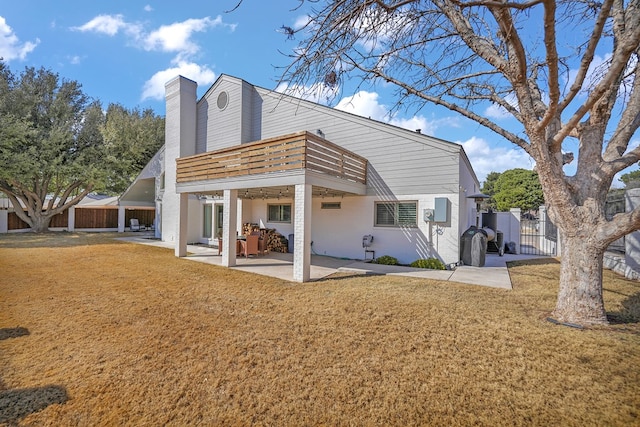 back of property with a patio, a yard, a chimney, and fence