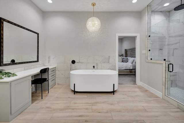 bathroom featuring connected bathroom, wood finished floors, tile walls, a freestanding bath, and a stall shower