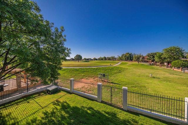 view of yard with fence and a rural view