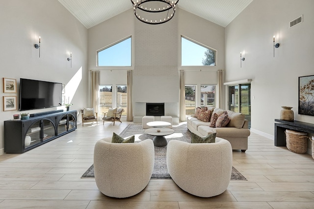 living room with visible vents, a fireplace, light wood-style flooring, and baseboards