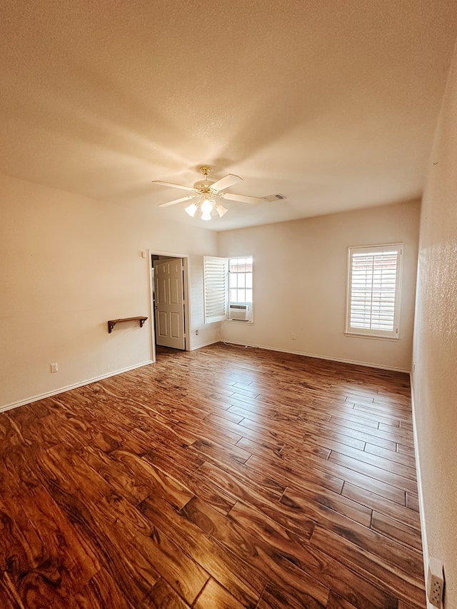 empty room with ceiling fan, hardwood / wood-style floors, and a textured ceiling