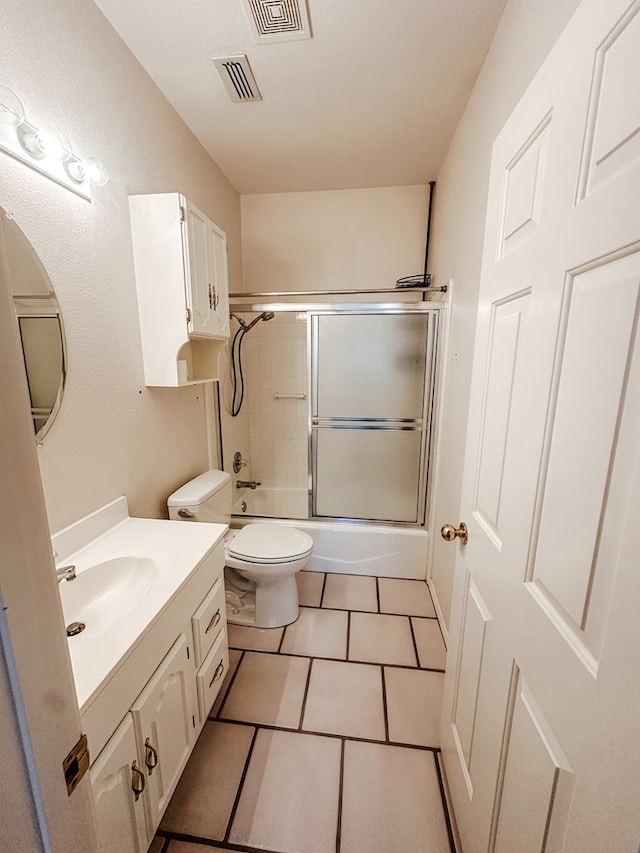 full bathroom featuring toilet, vanity, shower / bath combination with glass door, and tile patterned flooring