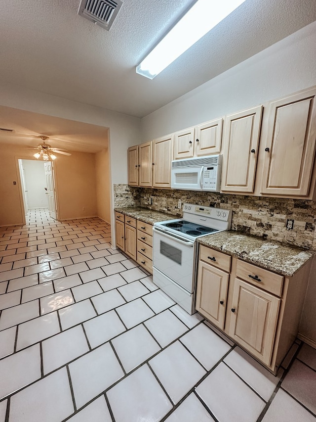 kitchen with light brown cabinetry, light stone counters, ceiling fan, white appliances, and backsplash