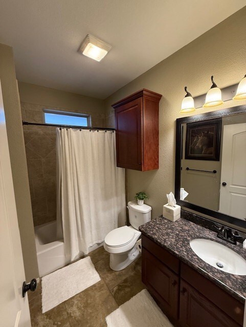 bathroom featuring vanity, shower / bathtub combination with curtain, and toilet