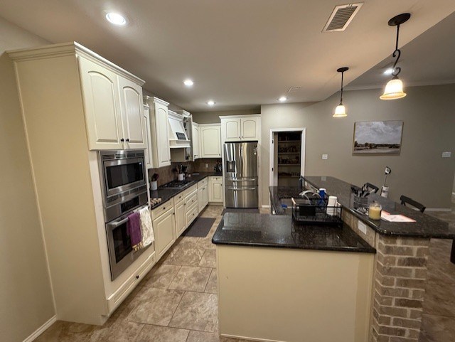 kitchen with visible vents, recessed lighting, a center island, hanging light fixtures, and stainless steel appliances