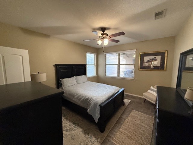 bedroom with a ceiling fan, baseboards, and visible vents